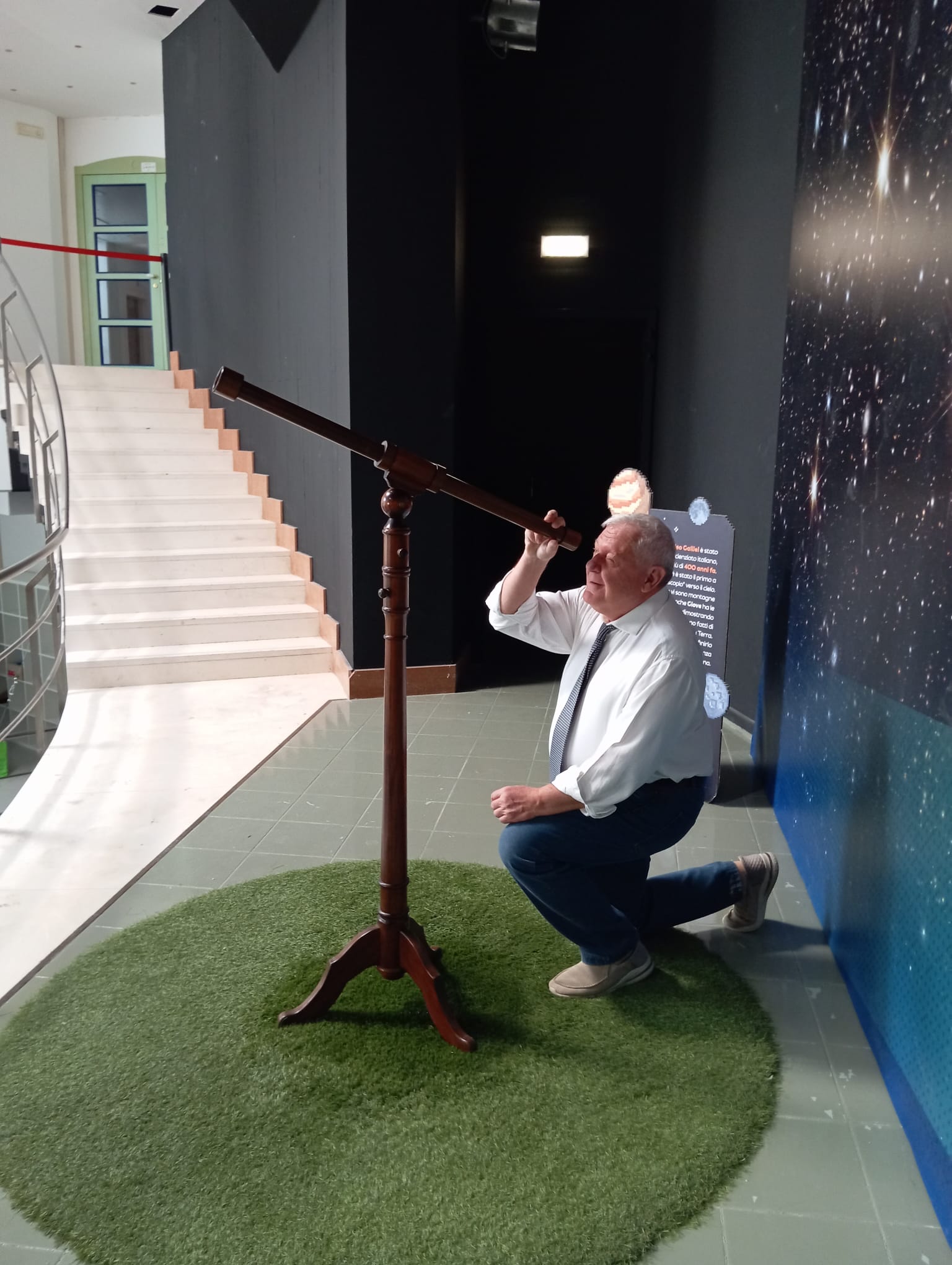 Il Prof. Vespri osserva dentro un cannocchiale d'epoca, in una mostra dedicata a Galileo